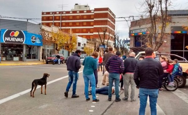 Uno de los ocupantes de la motocicleta que realizo un giro inoportuno, esta siendo asistido por vecinos que se acercaron