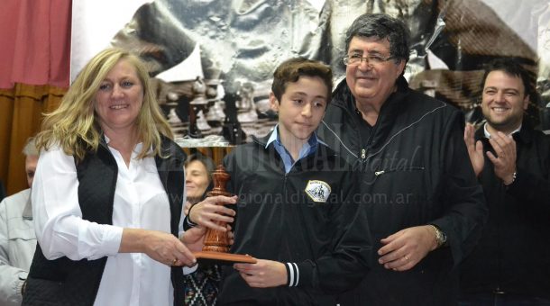 Valentin Heredia recibe de parte de sus padre el trofeo como campeon en Sub 18