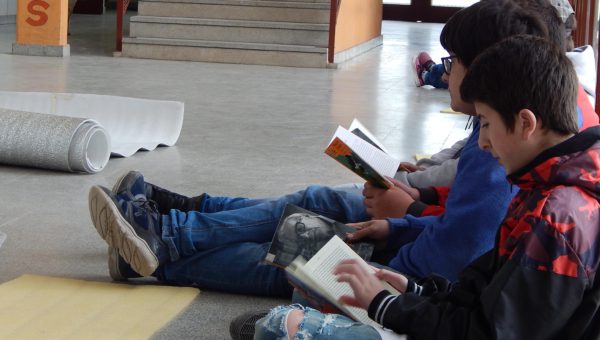 Un grupo de alumnos procede a la lectura de libros tomados de la Biblio Movil