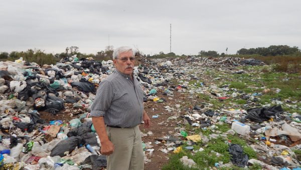 Angel Pajon en el limte de su propiedad, detras residuos que han sido arrojado no hace mucho tiempo