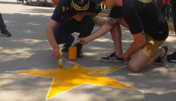 Un efectivo de Policia,Amigos y familiares de Iñaki en Gral Viamonte pintando la primera Estrella Amarilla