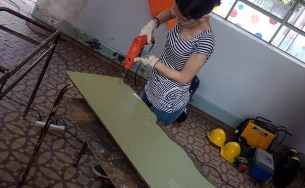Una alumna en plena tarea de restauracion de una mesa de estudio en French