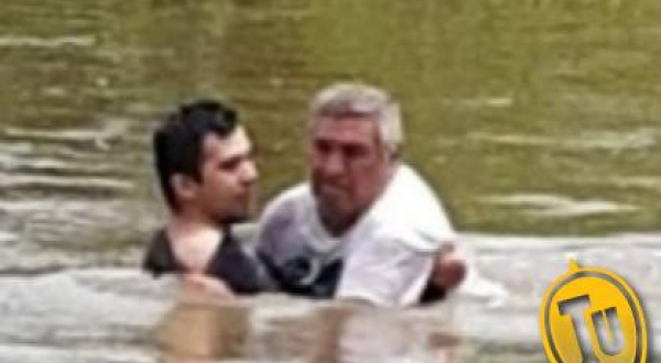 El hombre de 64 años siendo rescatado por el efectivo de la policia correntina