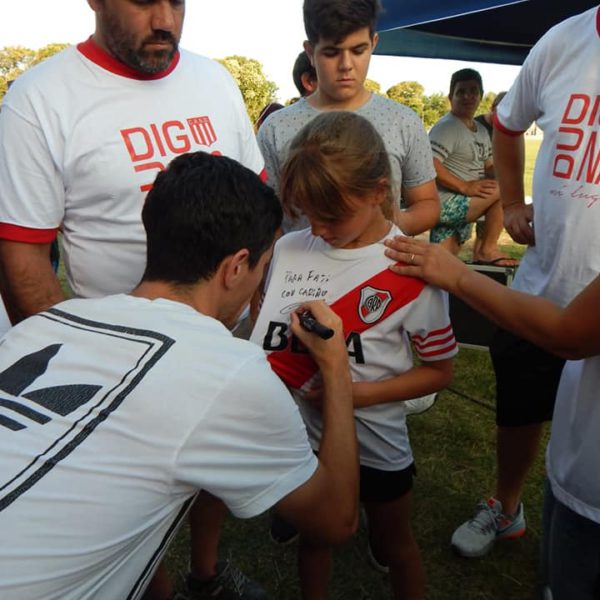 Fernandez firmando la camiseta de una niña