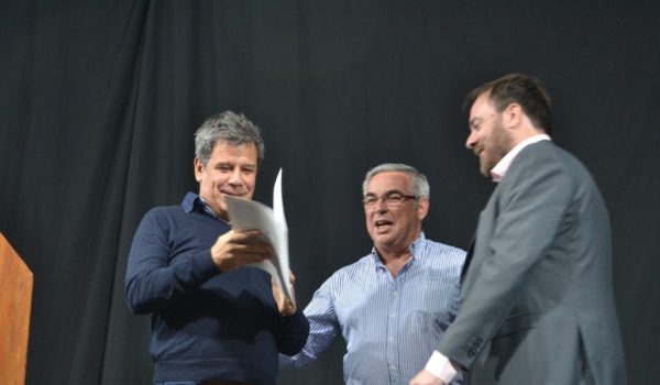 Jorge Della Rocca junto a Matias Losinno entregan una copia de la Declaracion Municipal
