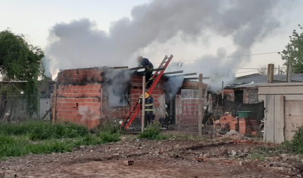 Bomberos trabajando sobre la vivienda damnificada por el fuego